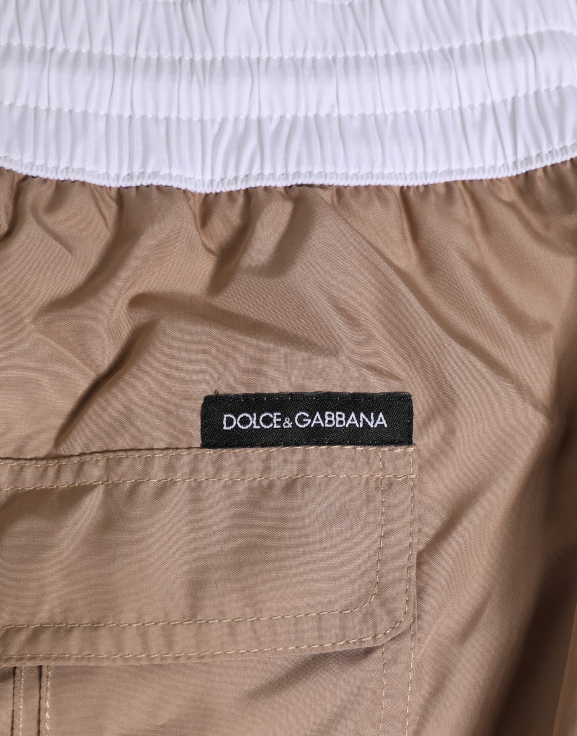 Brown shorts with white trim and a black label that says Dolce & Gabbana