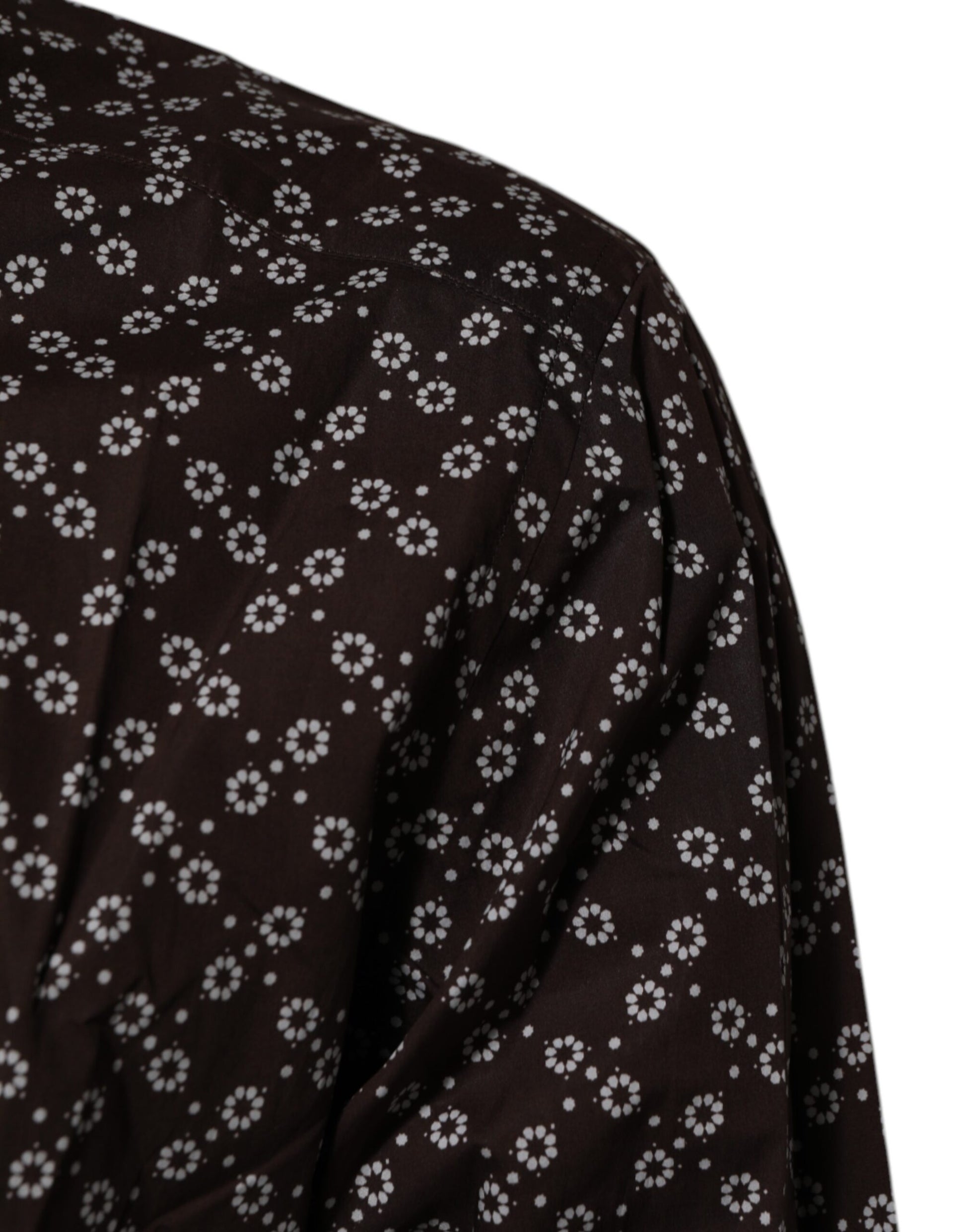 A black collared shirt with a floral pattern and gold accents