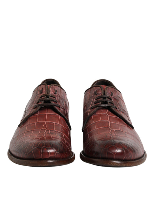 Pair of burgundy leather lace-up dress shoes with a crocodile skin texture