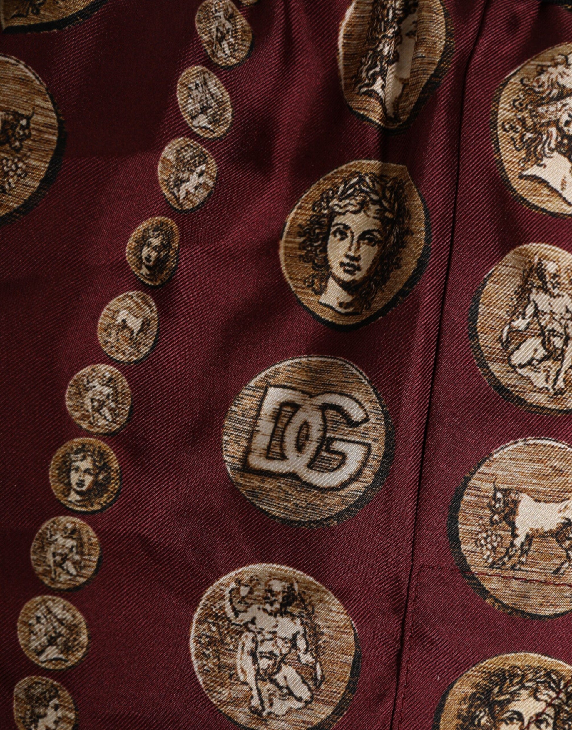 The tie has a pattern of coins featuring Roman gods and goddesses