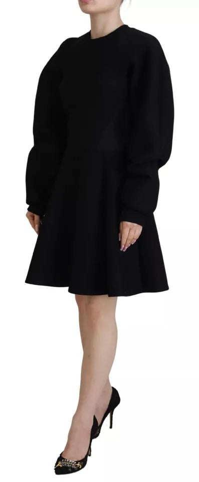 A black cotton dress with long sleeves and an A-line skirt. It is designed by Dolce & Gabbana, and it appears