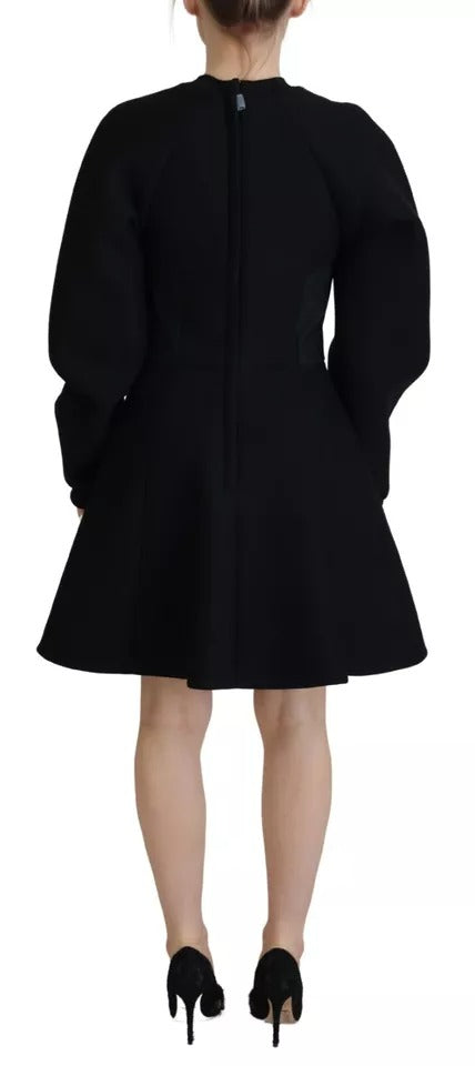 A black long sleeve dress with an A-line silhouette. It features a high neck and is made of cotton fabric