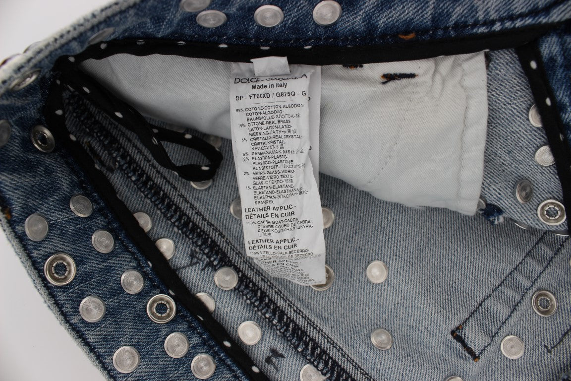 Blue denim jeans with silver studs and a white tag attached to waistband