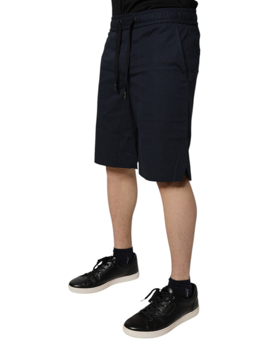 A pair of dark blue cotton bermuda shorts with an elastic waistband