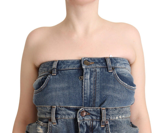 A woman wearing a denim jumpsuit dress with no straps, featuring a dark blue wash and visible stitching details