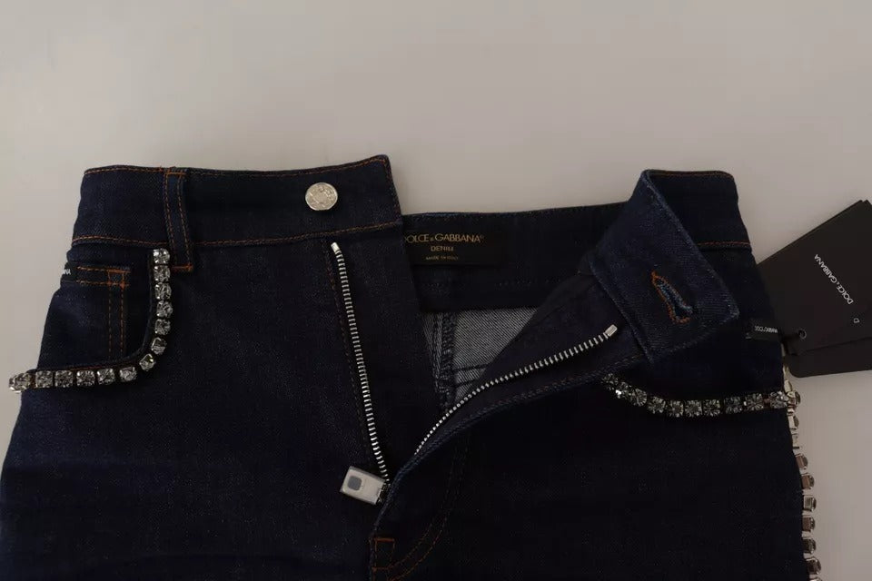 A pair of dark blue denim shorts with embellishments and a zippered front