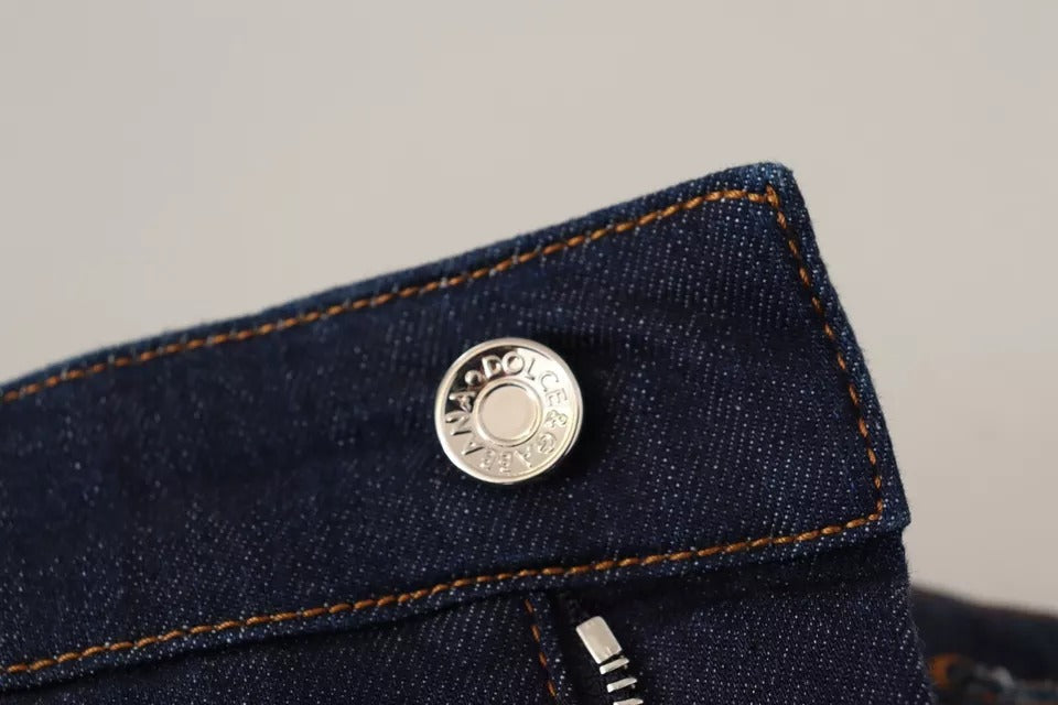 A pair of dark blue denim shorts with an embellishment on the left side