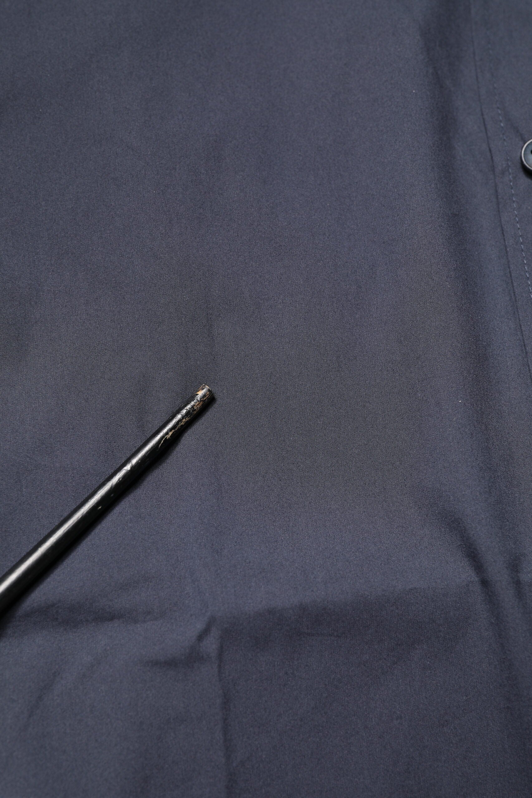 A dark blue dress shirt with a gold design on it, made of cotton