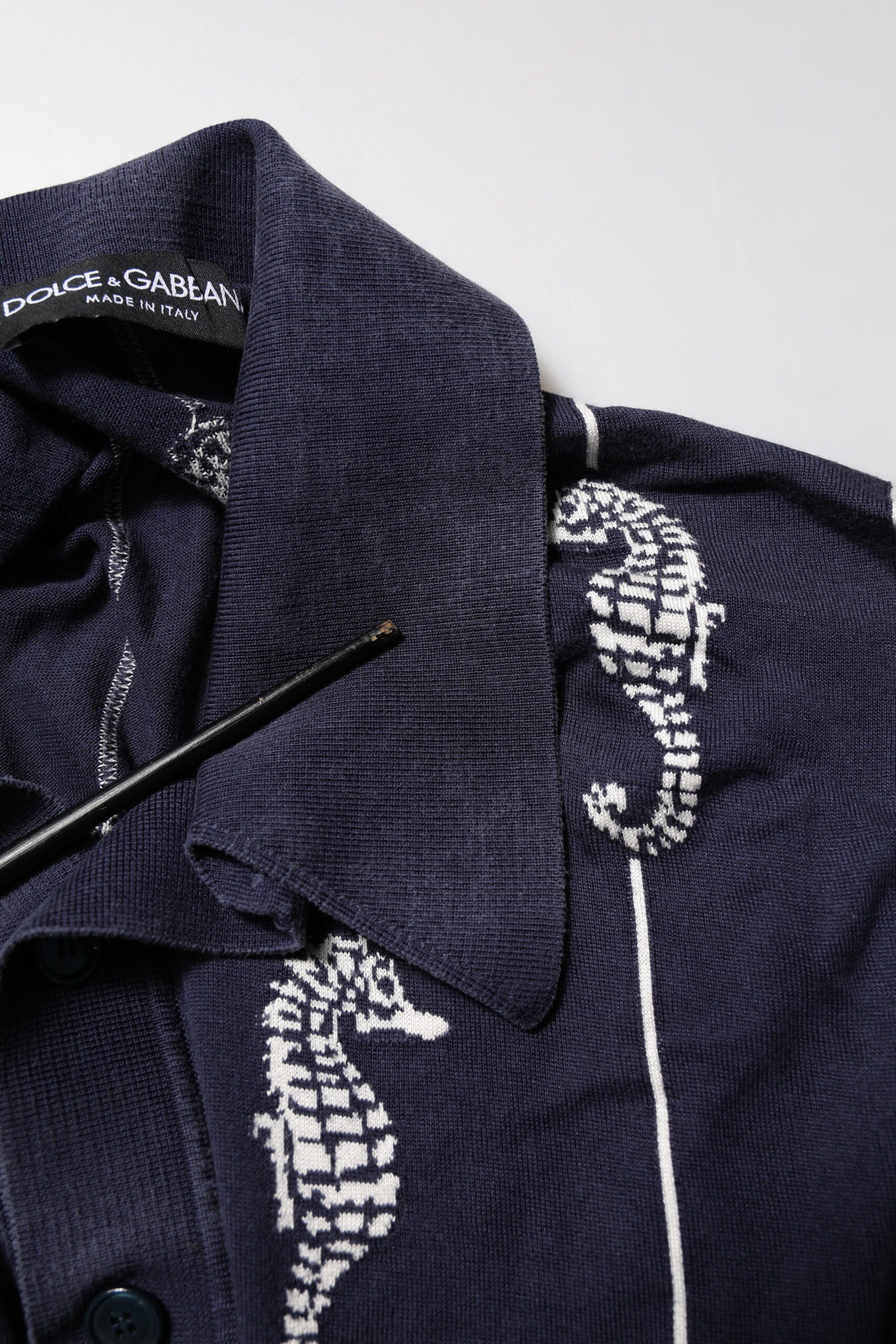 Blue polo shirt with white stripe on collar and embroidered design
