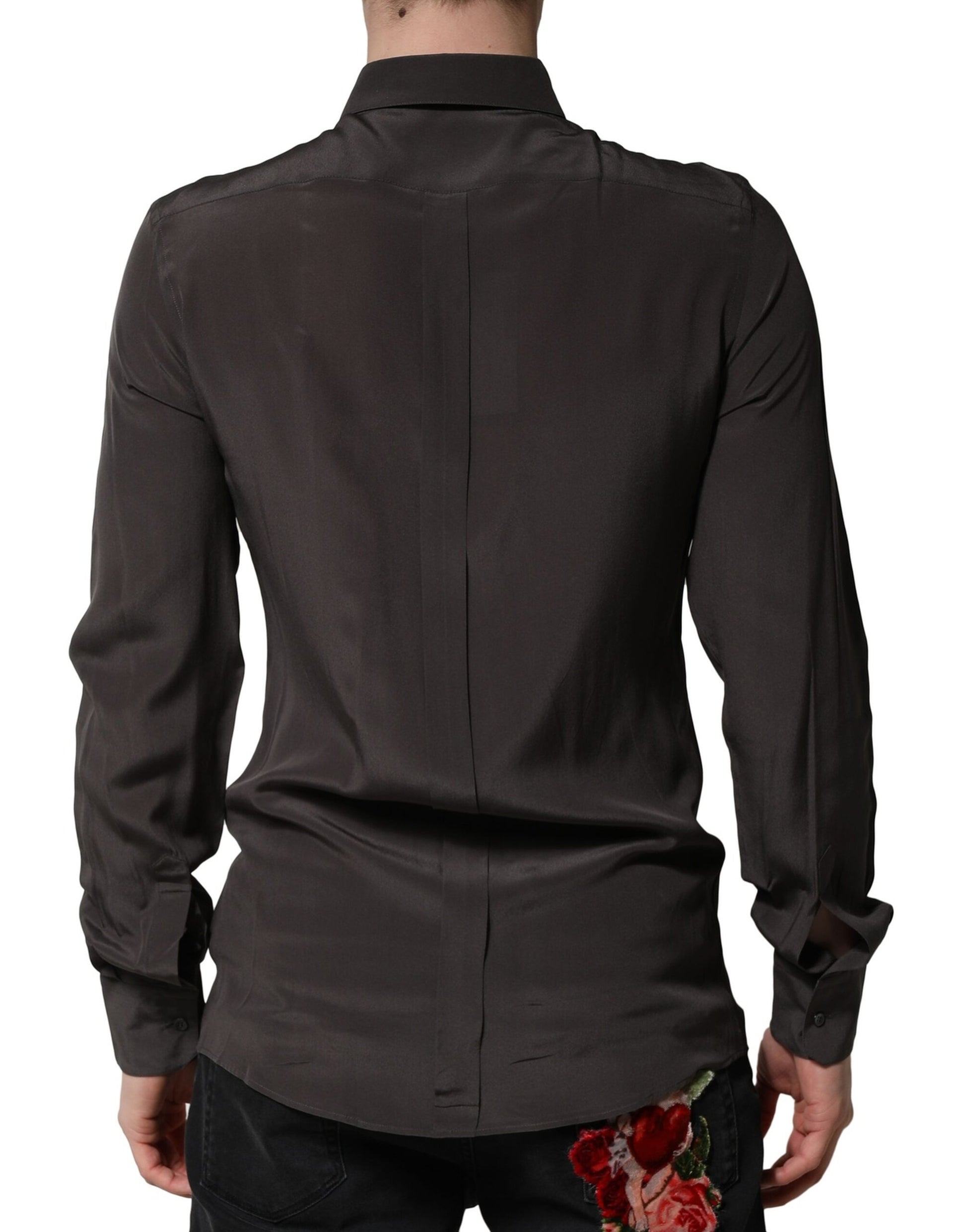 A mannequin wearing a dark brown silk shirt with a gold collar
