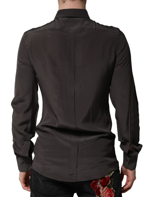 A mannequin wearing a dark brown silk shirt with a gold collar