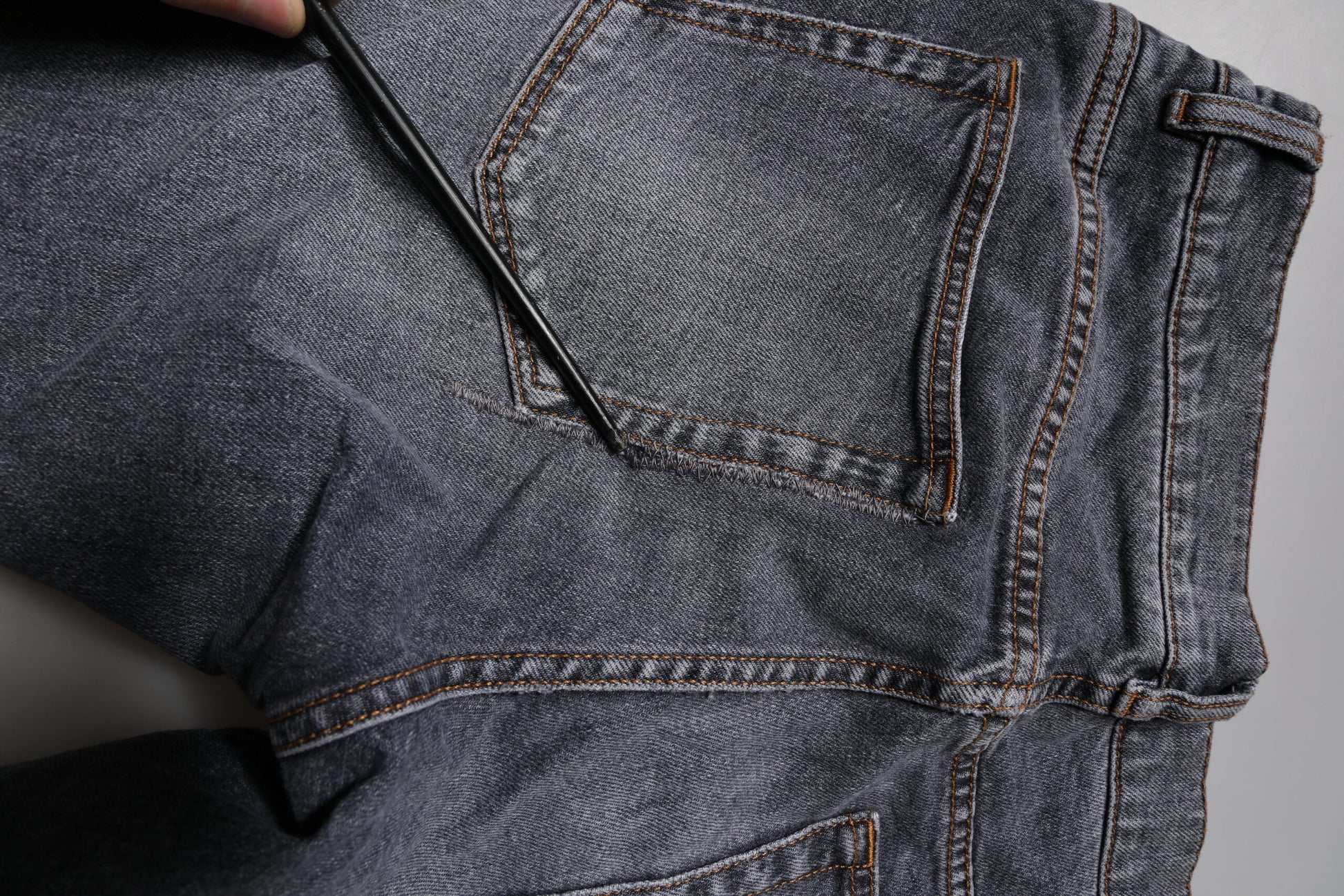 Pair of blue jeans with brown stitching on pocket