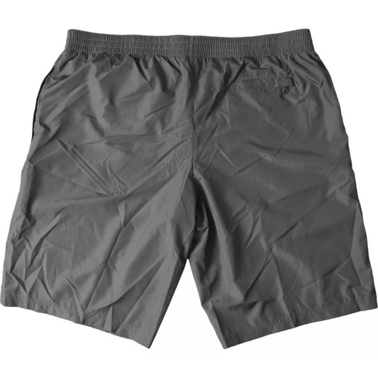 A pair of dark gray polyester beachwear shorts. They are designed for men and feature an elastic waistband wi