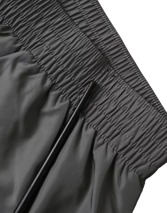 A pair of dark gray polyester beachwear shorts. They feature a textured pattern and are designed for men's sw