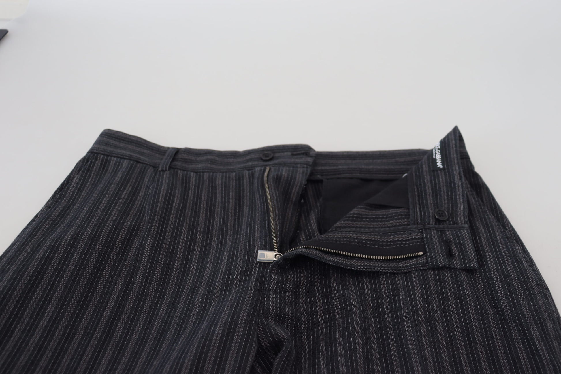 A pair of dark gray chino dress pants with a striped pattern, featuring a zipper fly and belt loops