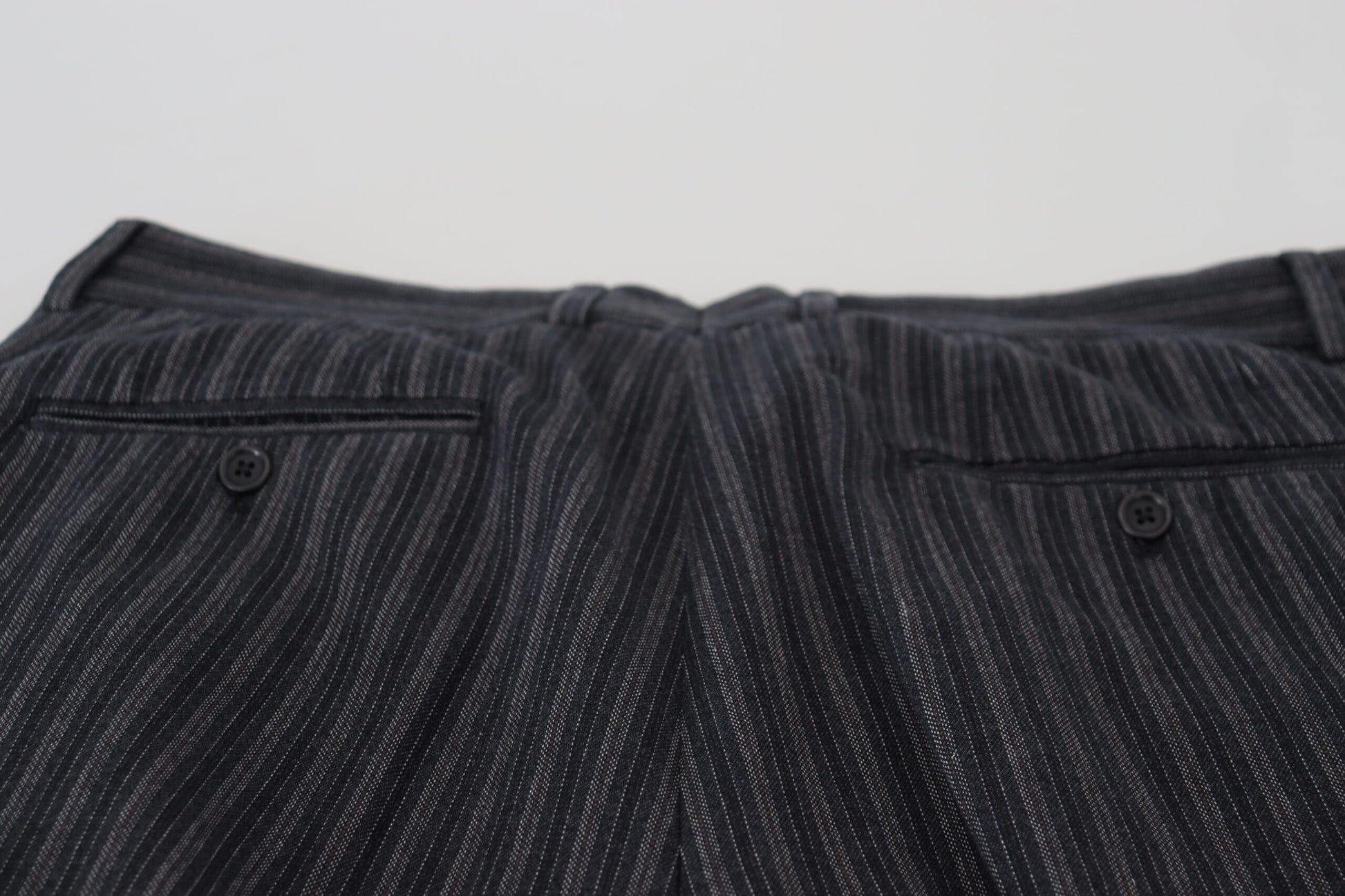 A pair of dark gray chino dress pants with a striped pattern, featuring two pockets on the front