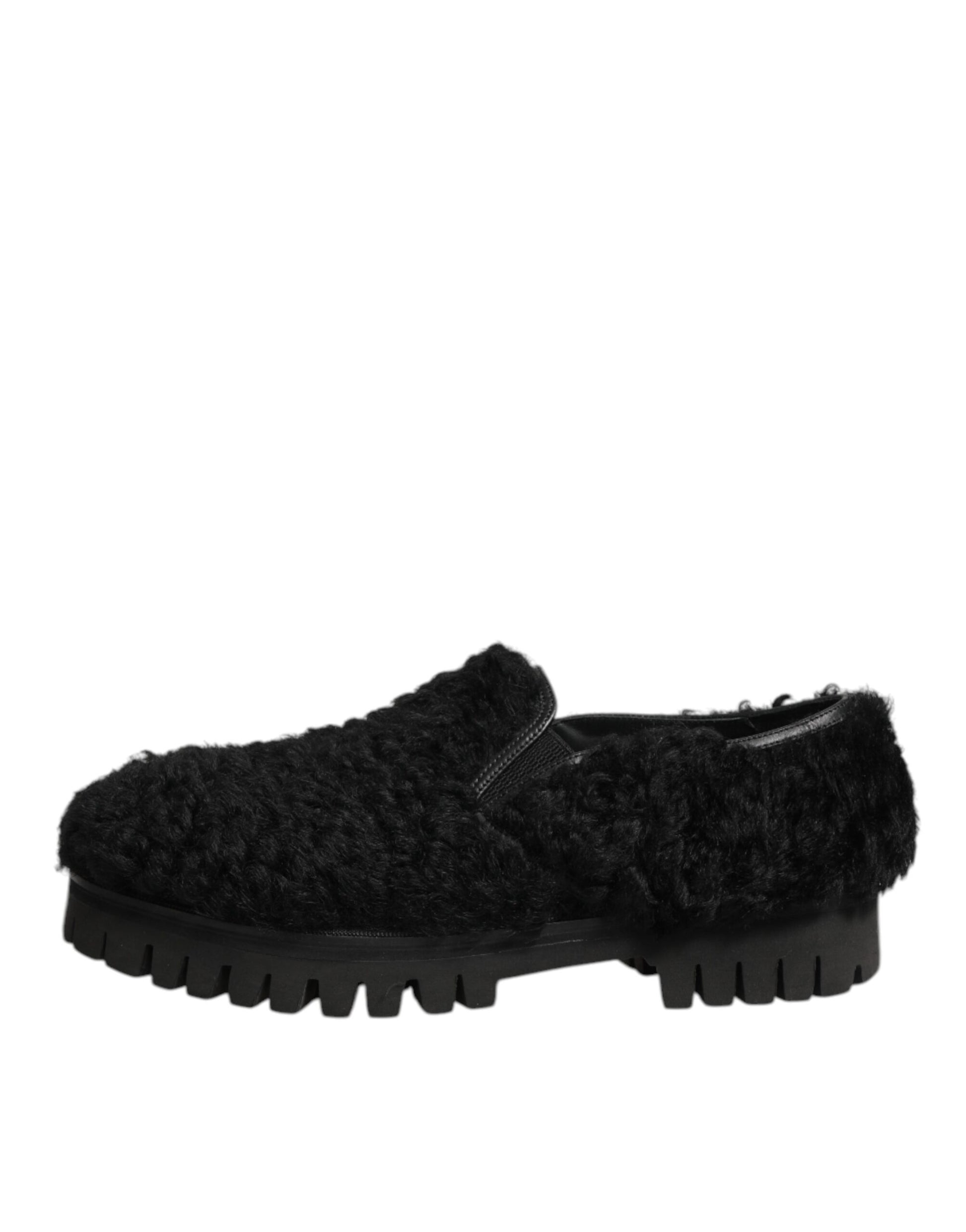A pair of black fur lined leather slippers with a chunky sole, designed by Dolce & Gabbana