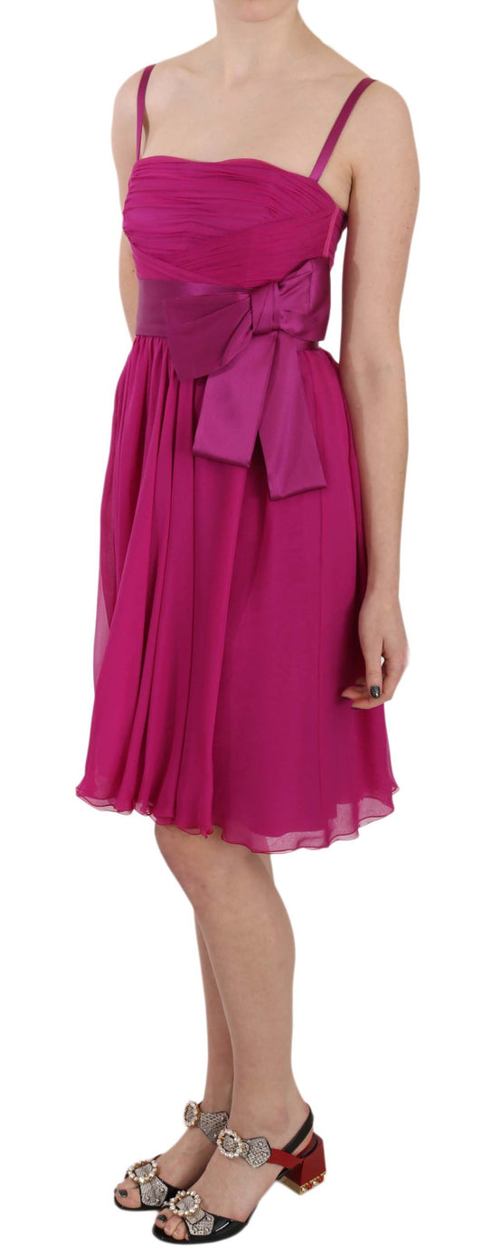 A sleeveless pink dress with a bow on the waist, designed by Dolce & Gabbana