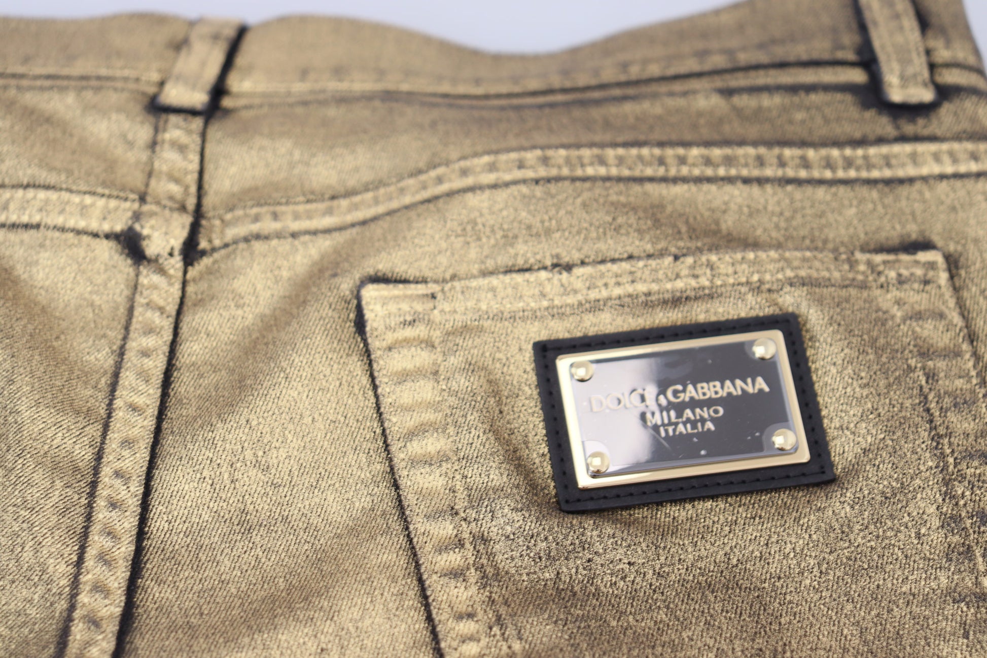Tan jeans with a branded label on the front pocket