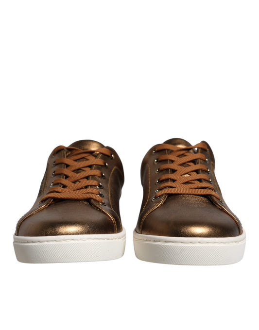 Pair of gold leather sneakers with brown laces and logo on side, designed by Dolce & Gabbana