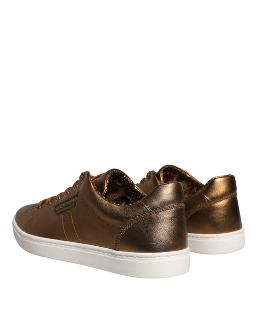 Pair of gold leather sneakers with black laces and white soles, featuring the D&G logo