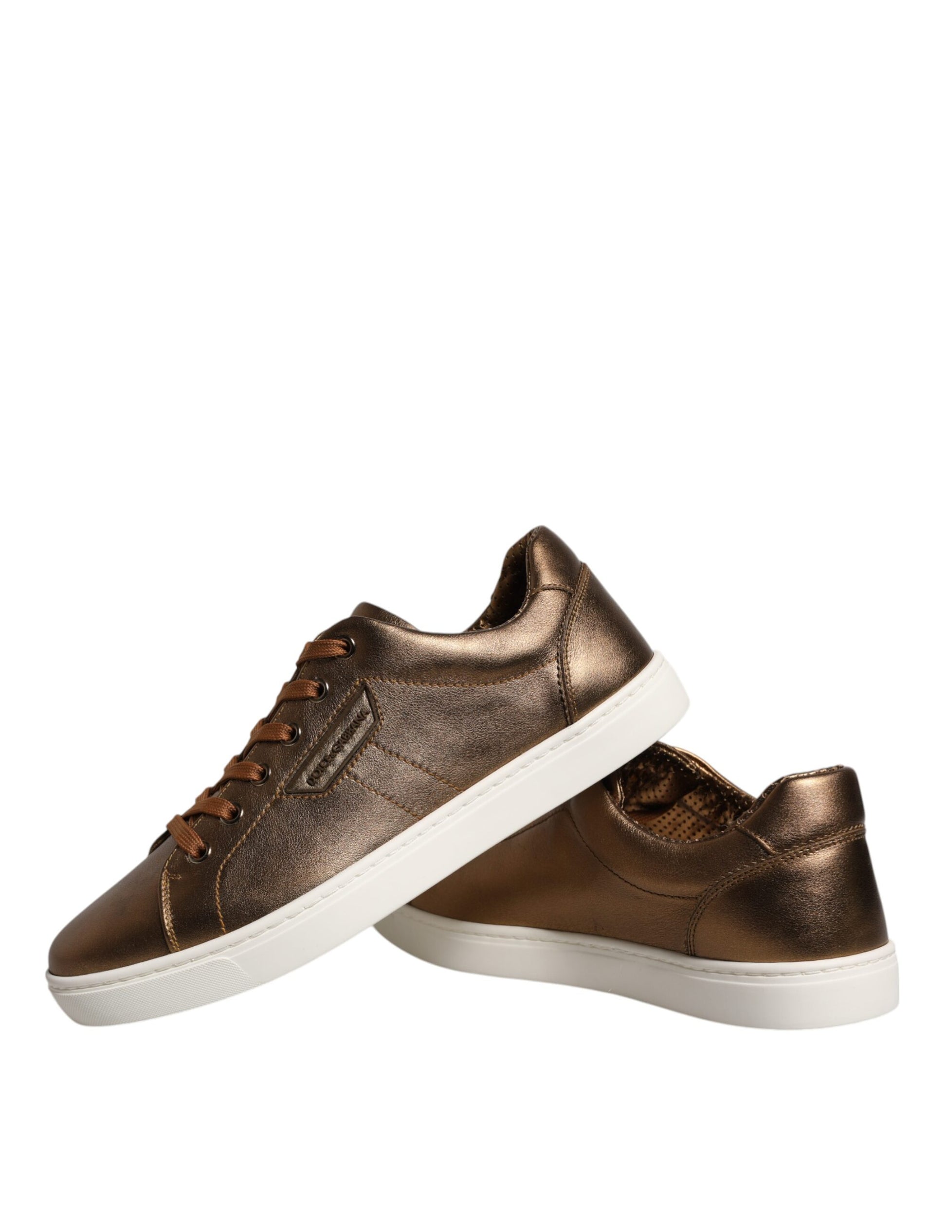 Pair of gold leather sneakers with black laces and white soles, featuring a logo on the side