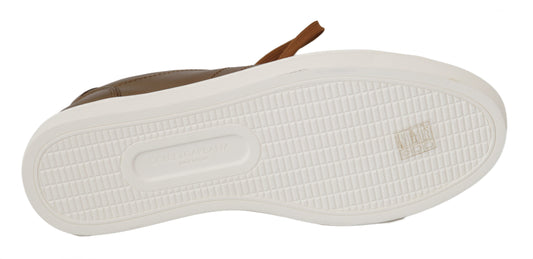 Pair of white sneakers with black laces and a brown logo on the side
