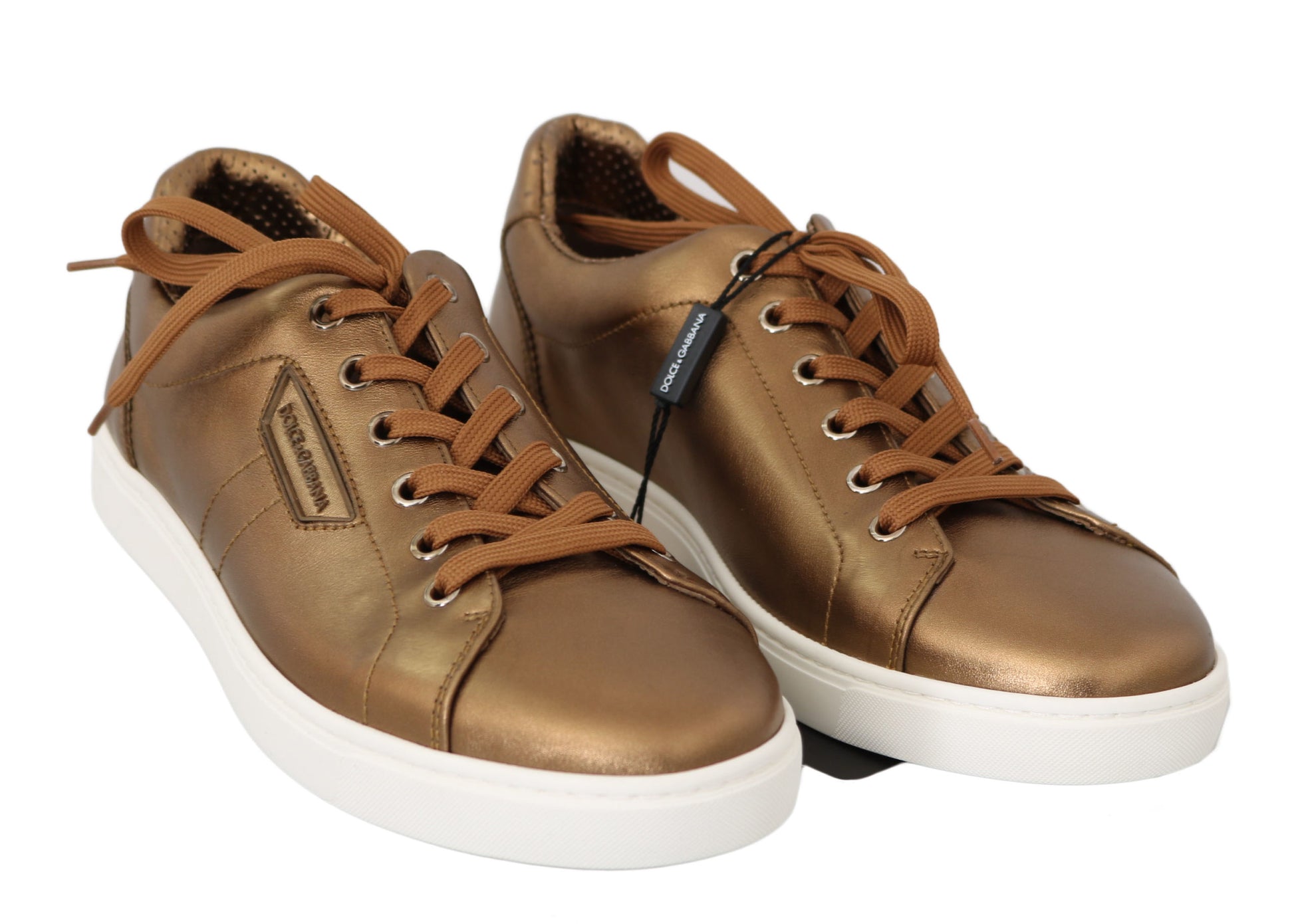 Pair of gold sneakers with white soles and laces