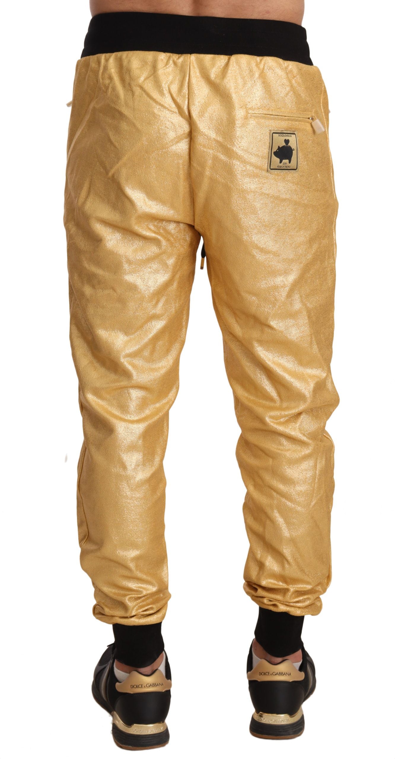 Yellow track pants with black logo on left leg
