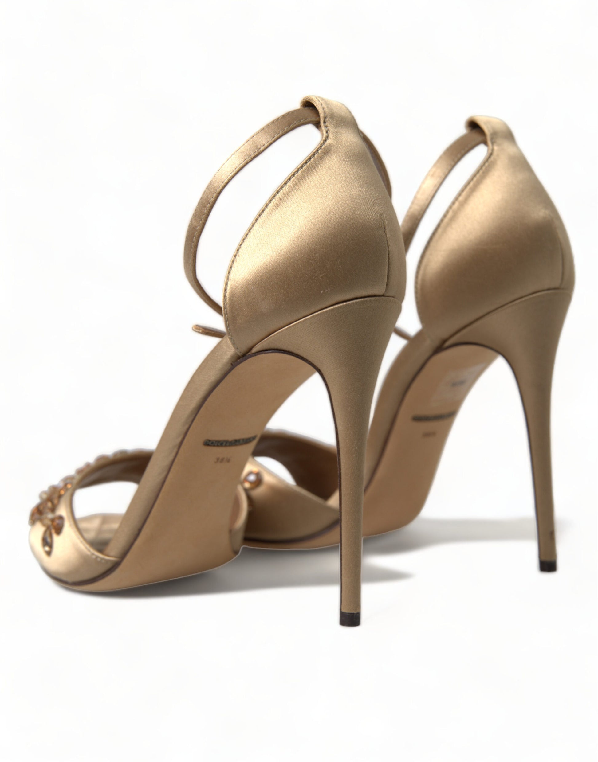 Gold high heel shoes with ankle strap and embellishments on the toe
