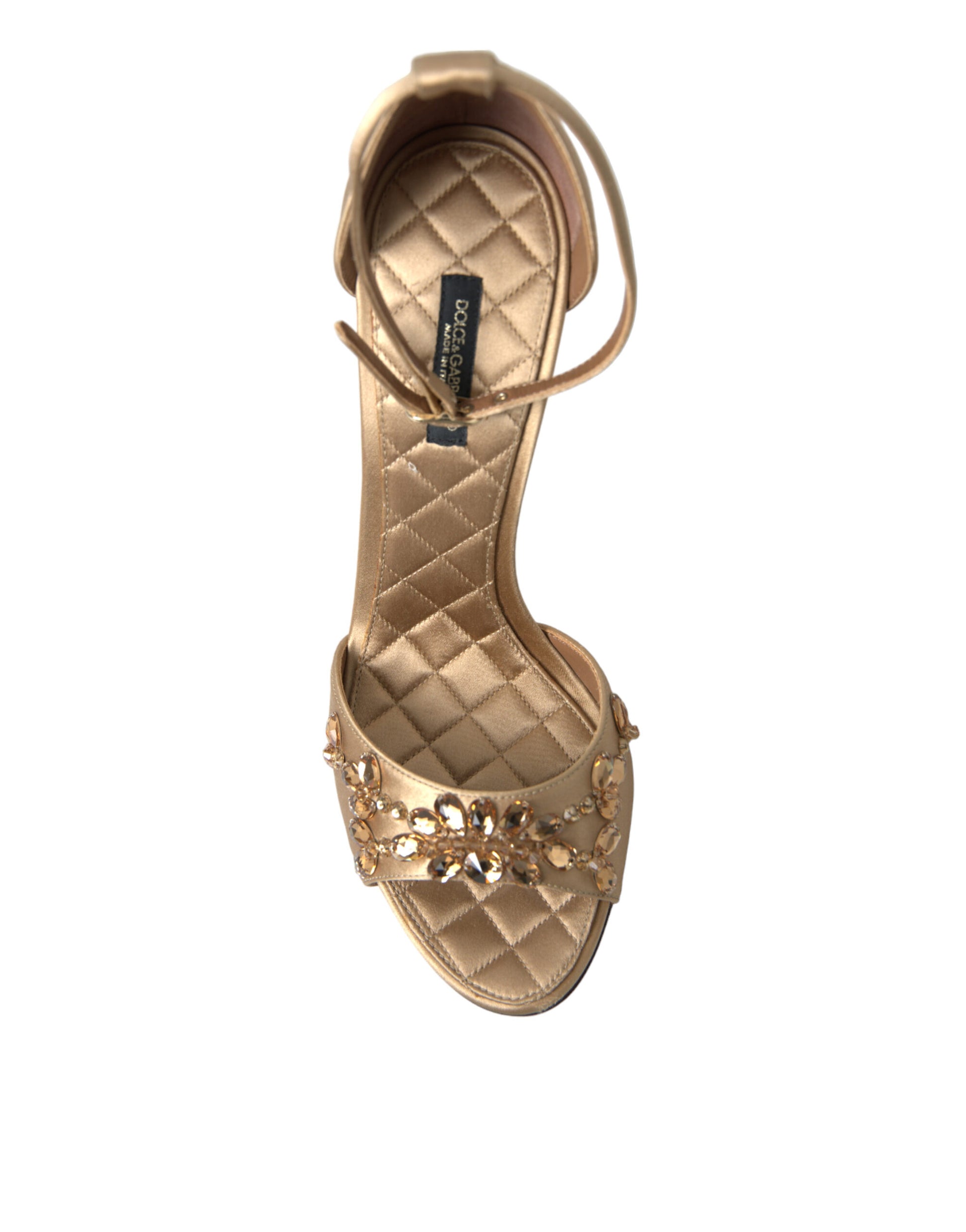 A single shoe against a plain background. It is a women's flat with a quilted design and embellished with what appears to