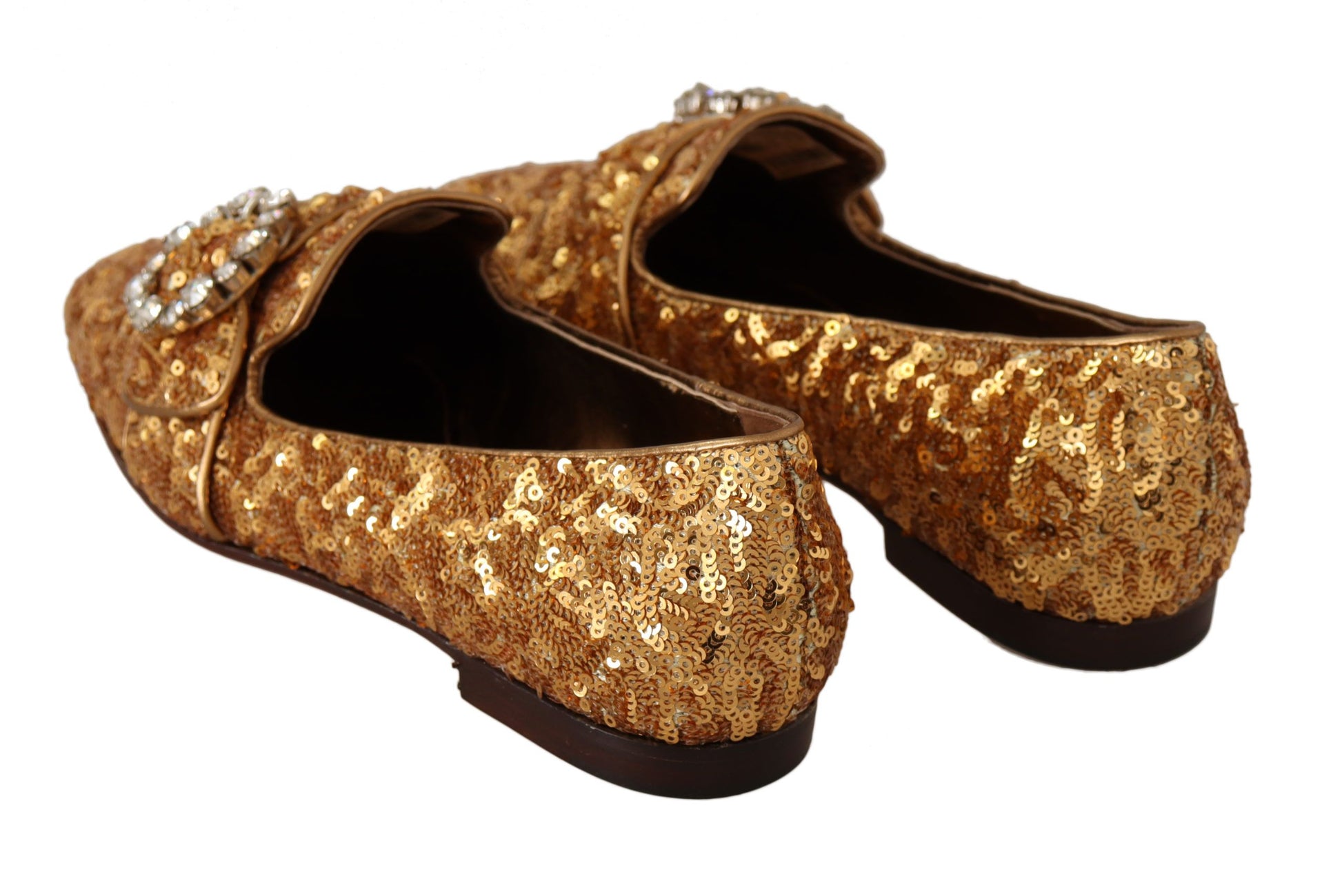Pair of gold glittery shoes with embellishments and heels
