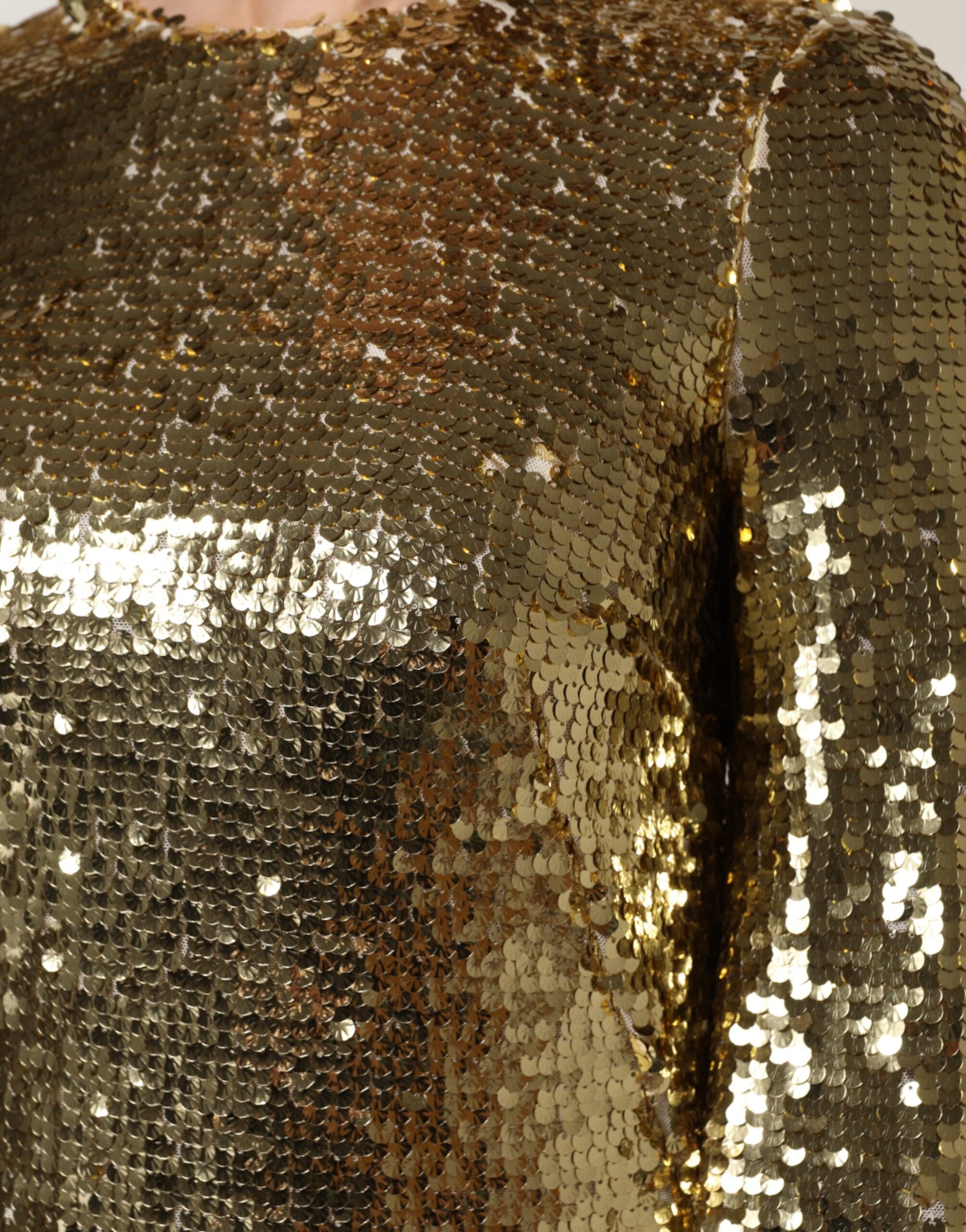 A long sleeved gold sequin dress with a shiny texture