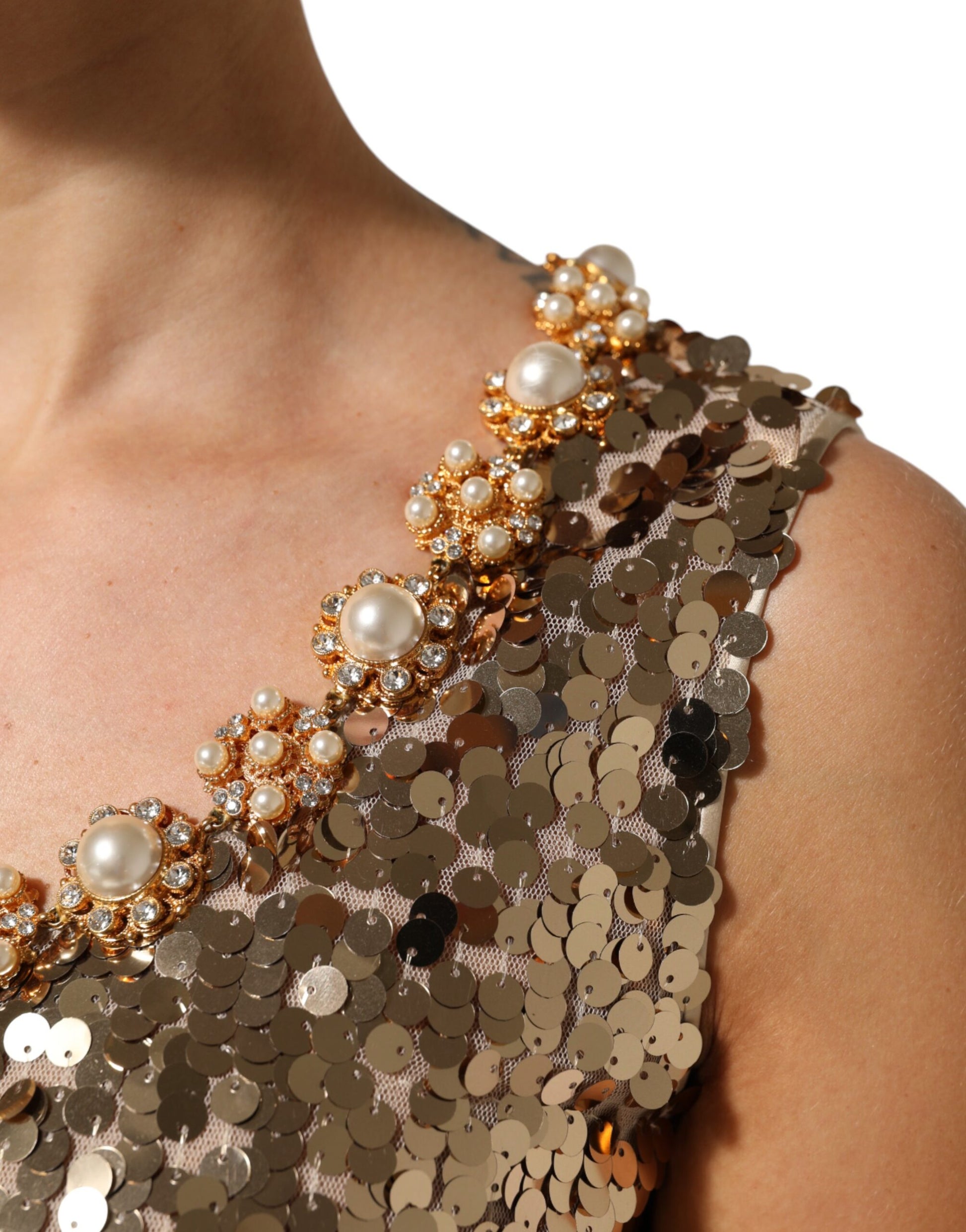 A gold sequined nylon dress with a sheer neckline and shoulder straps