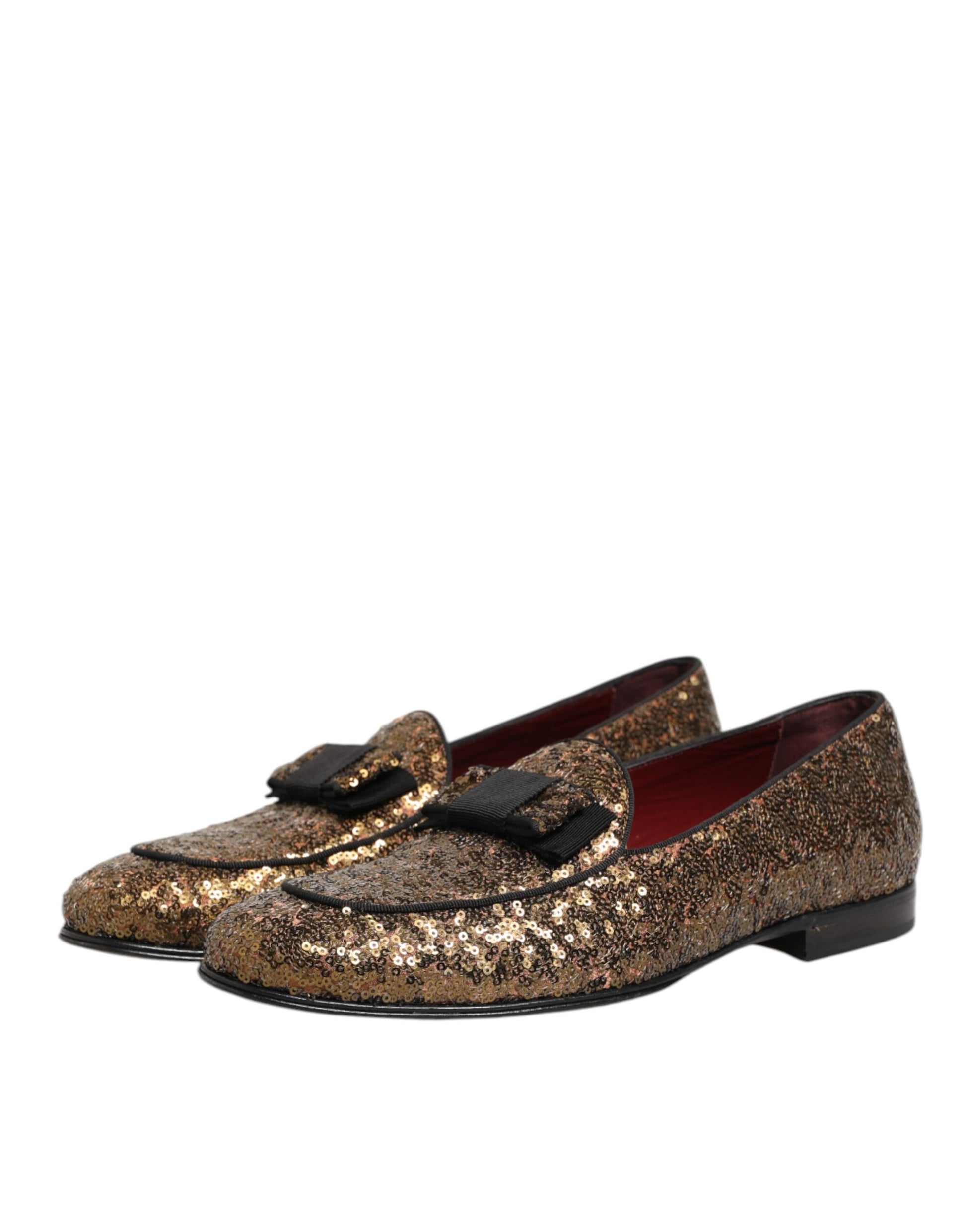 A pair of glittery gold sequin loafers with a black strap