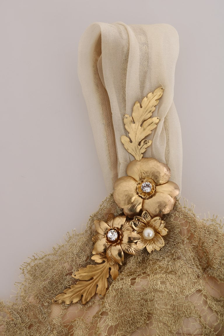 A gold silk dress with crystal embellishments and a leaf design on the shoulder