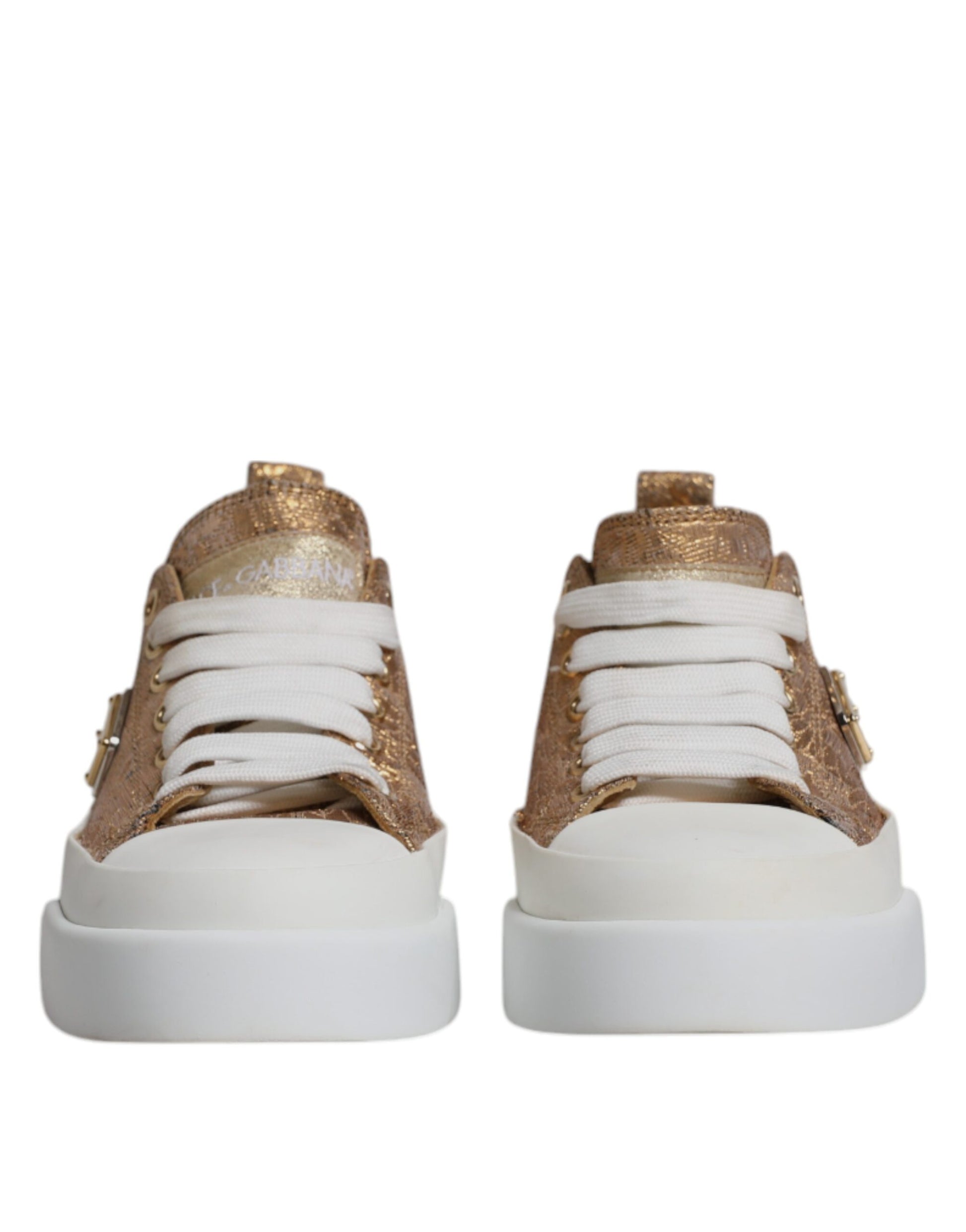Pair of white sneakers with gold logo detailing and laces