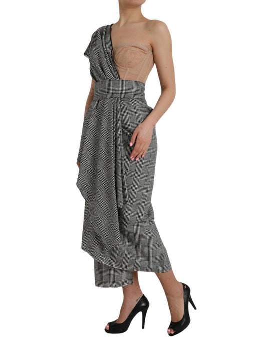 A woman wearing a gray beige layered one shoulder maxi dress with black and white pattern