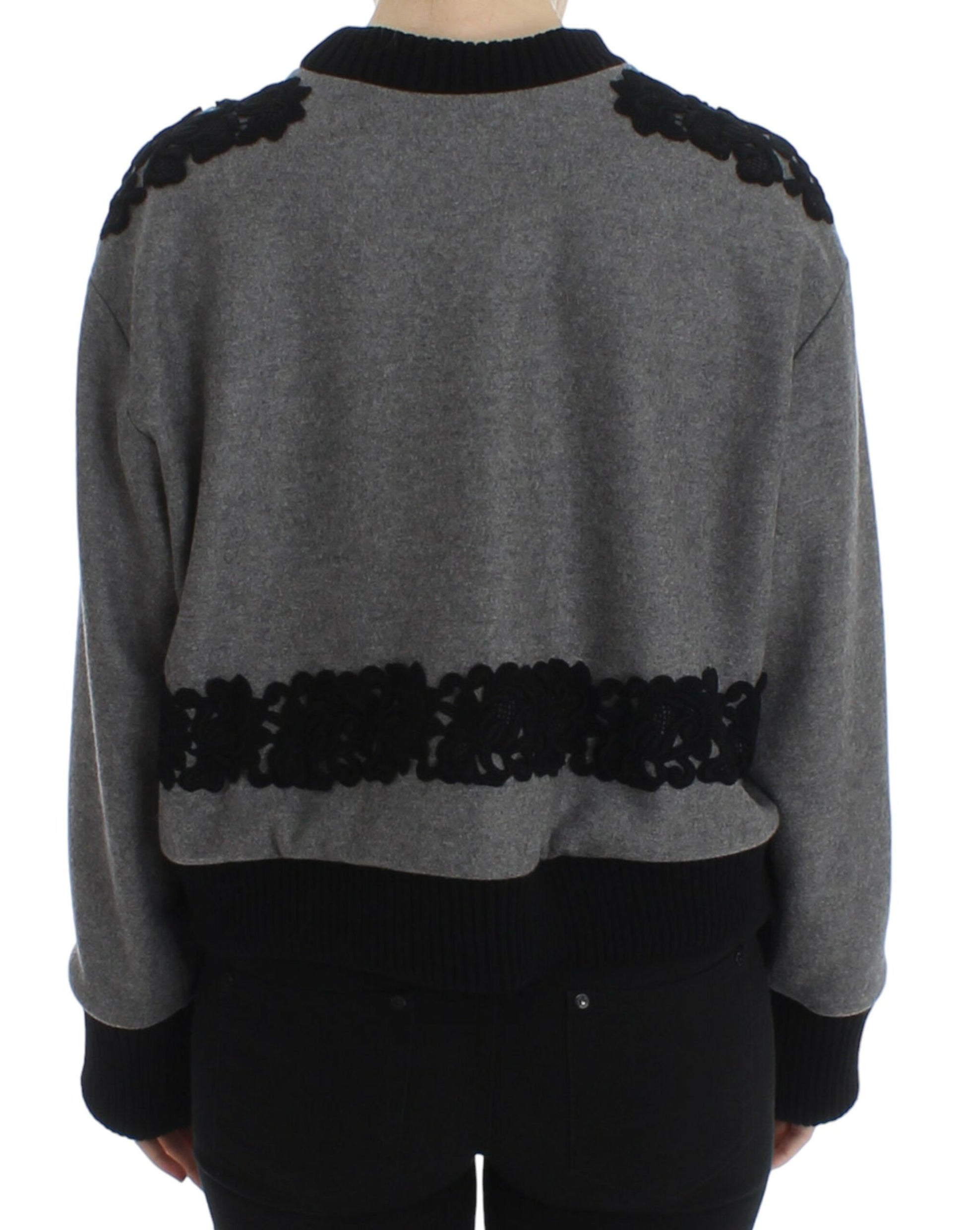 Grey knitted sweater with black trim and embroidered detailing on back