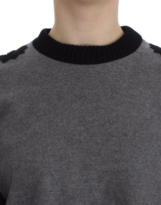 The sweater is gray and has a black collar