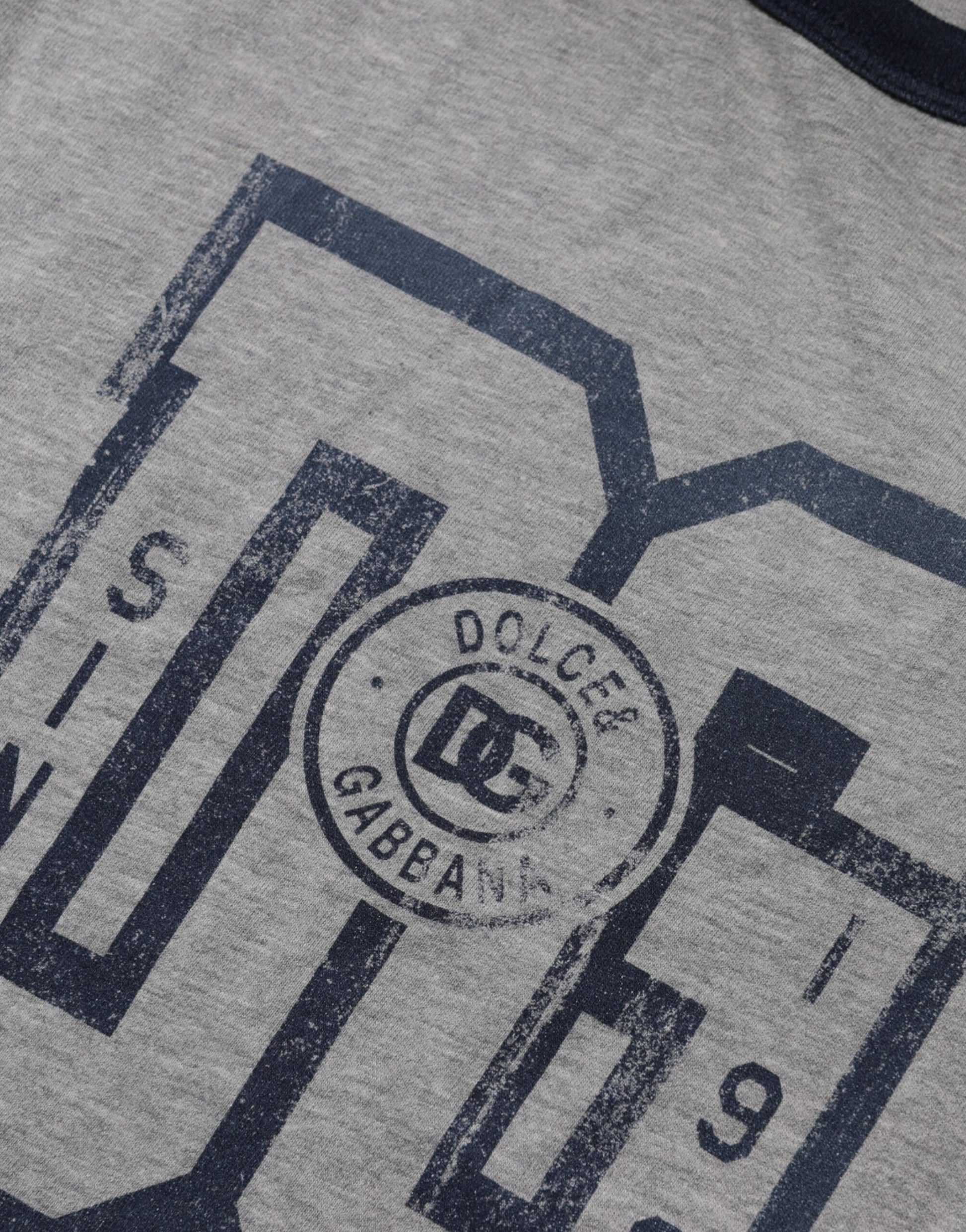 The shirt is gray with a logo on the front