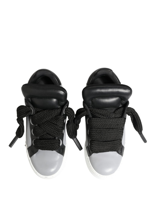 Pair of gray leather lace-up sneakers with black accents, featuring a low top and a shiny finish