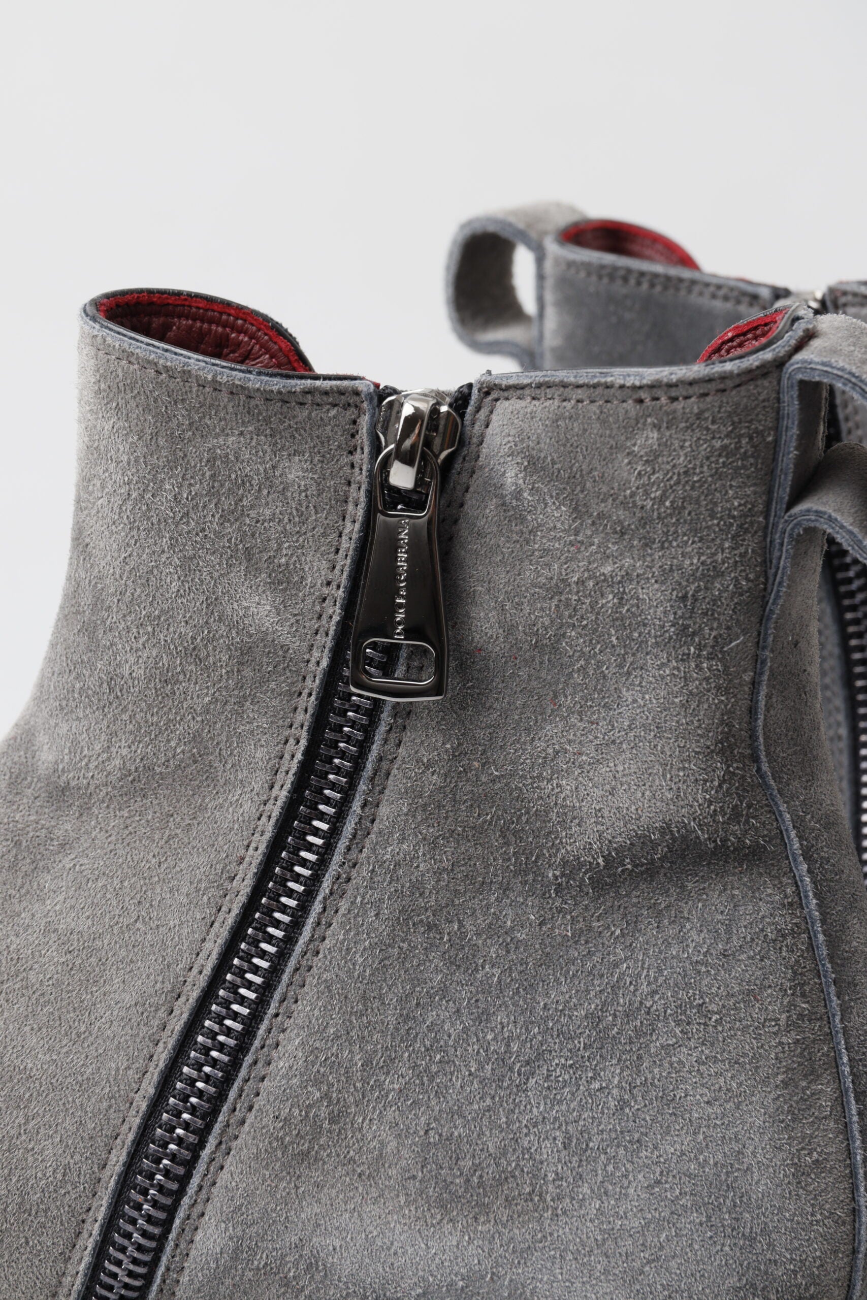 A gray boot with a zipper on the front