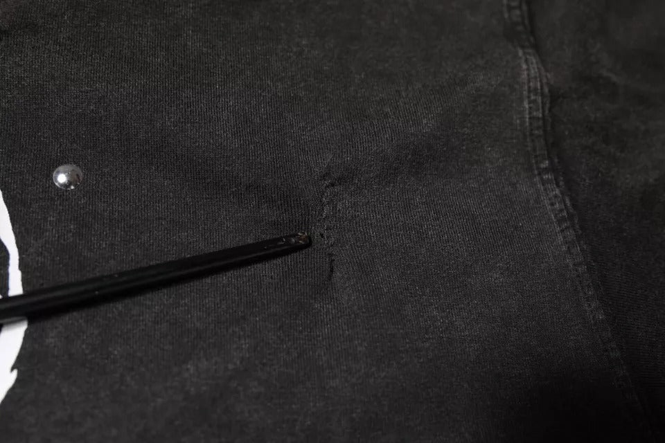 Black pants with a small hole in the knee area