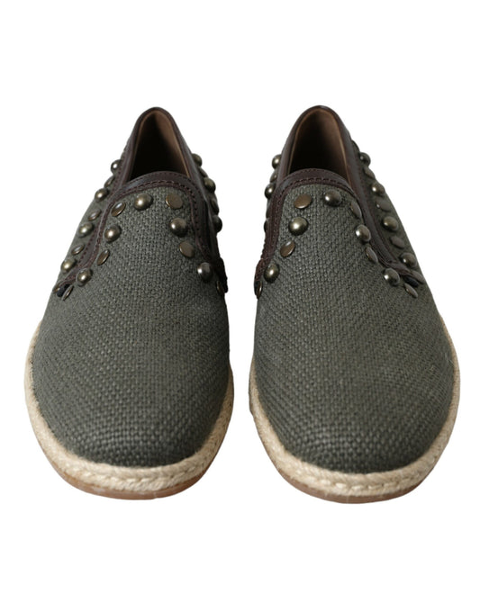 Pair of gray shoes with brown soles and silver studs on straps
