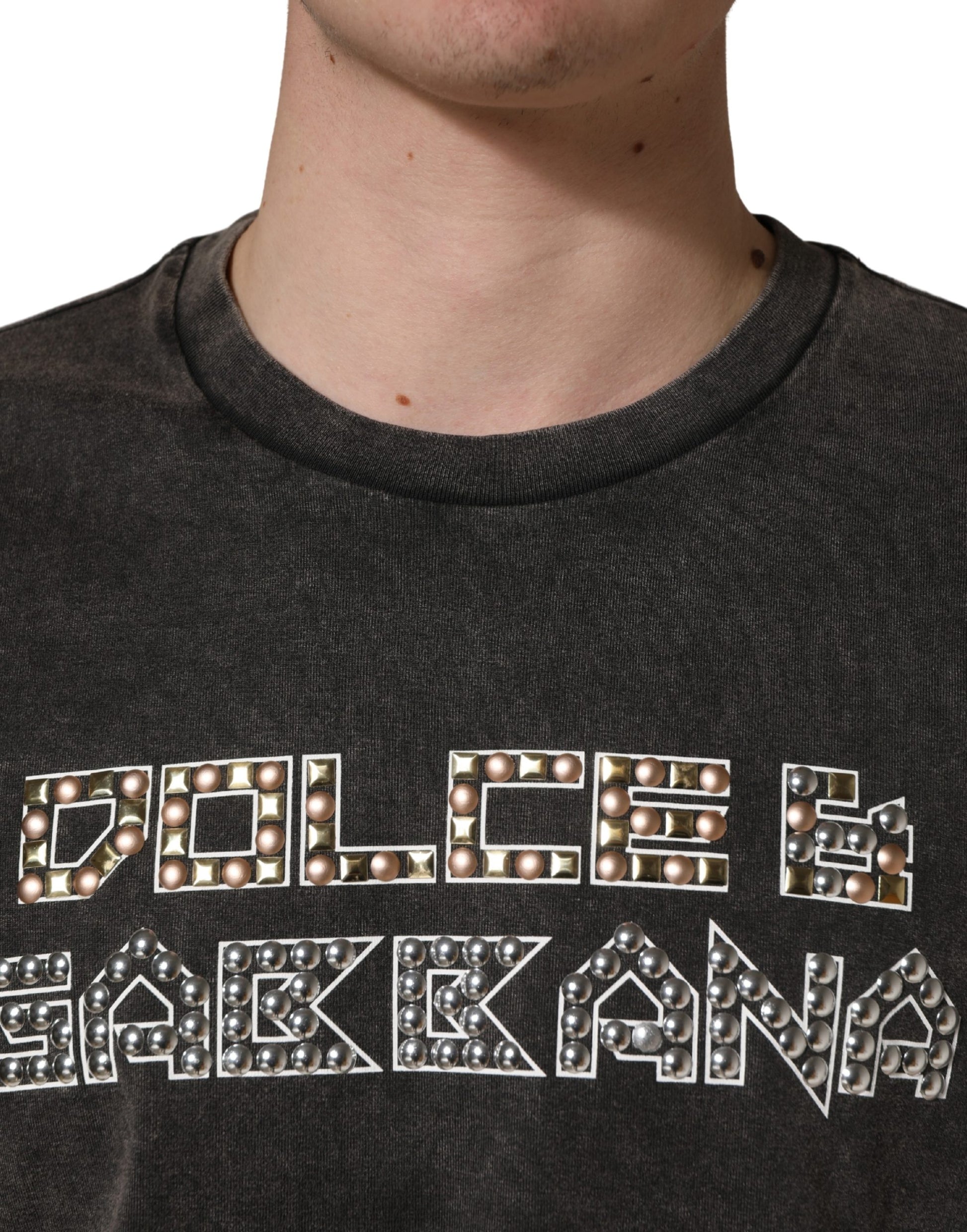 Man wearing a dark gray shirt with sparkling letters that say "Dolce & Gabbana"
