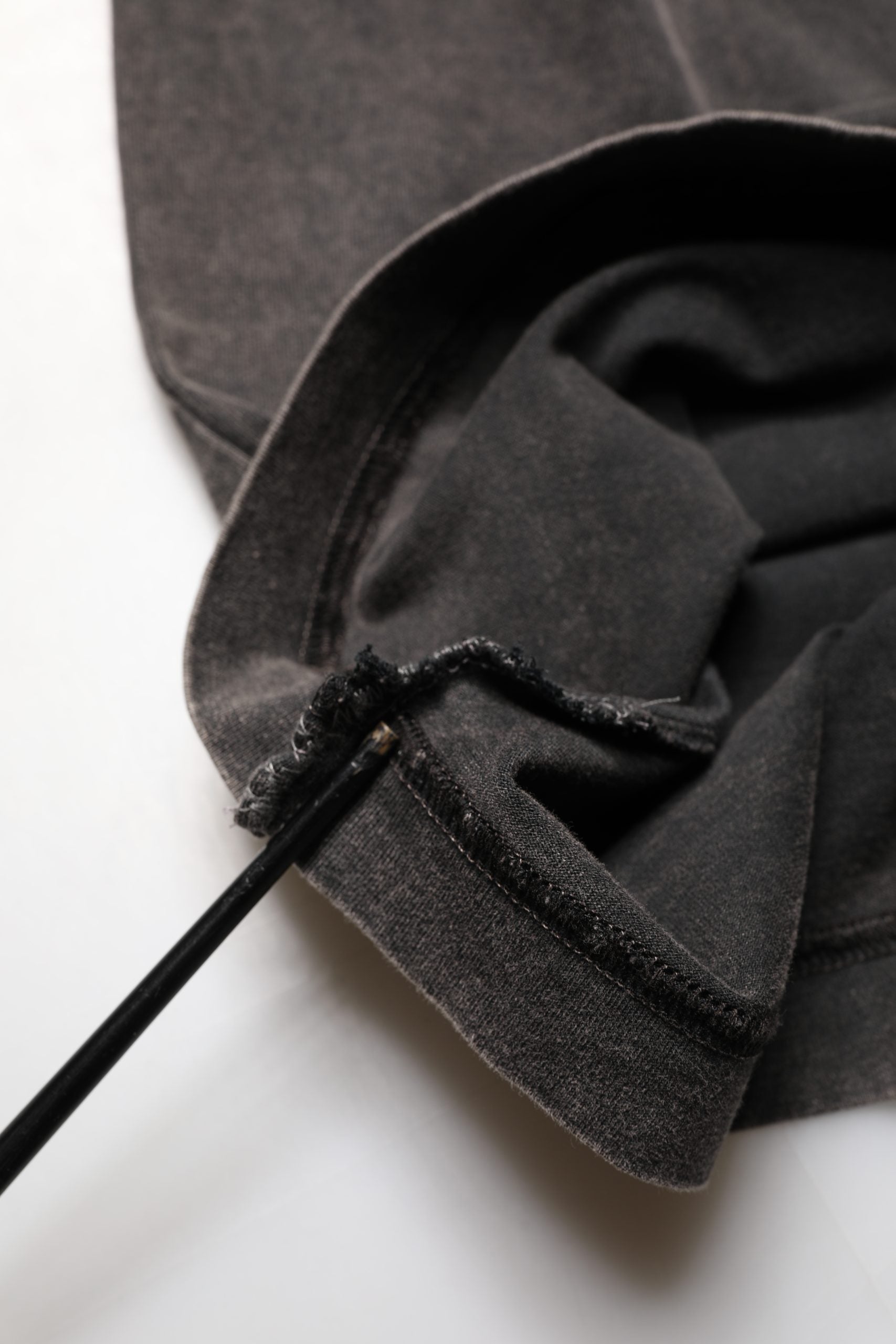 Brown fabric with black trim on a white surface