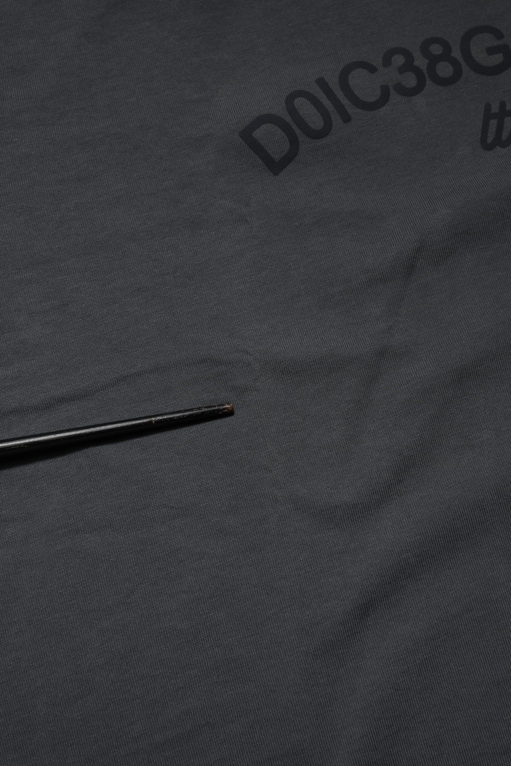 Black fabric with white lettering and a small pin in it