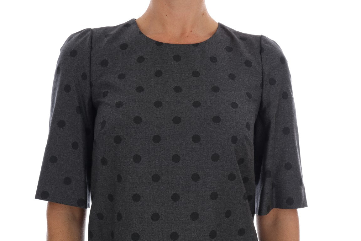 A gray polka dotted sheath wool dress with a V-neckline and short sleeves