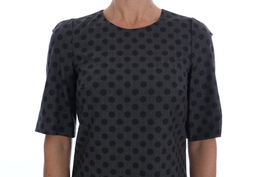 A black dress with gray polka dots, featuring a V-neck and short sleeves